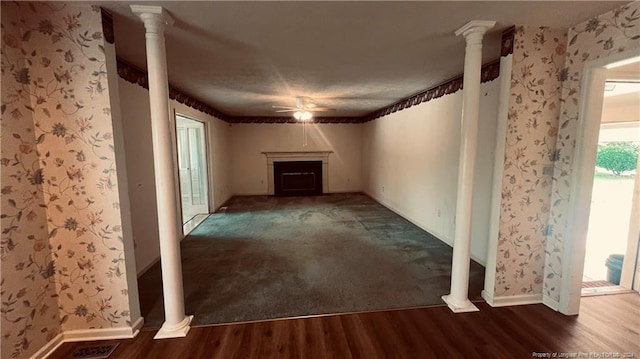 spare room with ceiling fan, decorative columns, and wood-type flooring