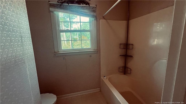 bathroom featuring tub / shower combination and toilet