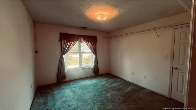 spare room with dark carpet