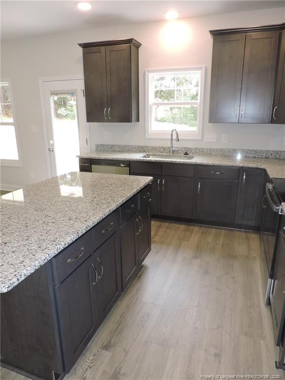 kitchen featuring range, dark brown cabinetry, sink, and light hardwood / wood-style flooring