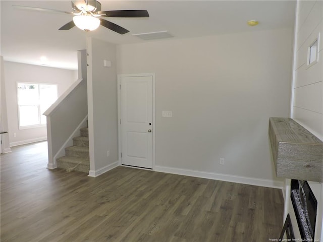 unfurnished living room featuring dark hardwood / wood-style floors and ceiling fan