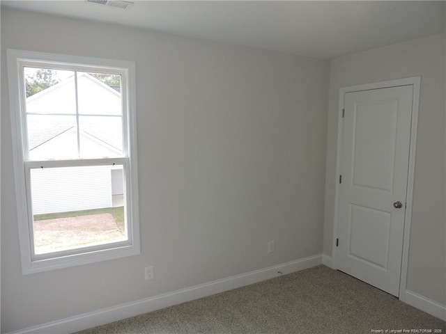 unfurnished room featuring light colored carpet