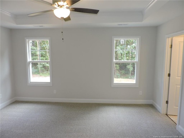 carpeted empty room featuring a tray ceiling, ceiling fan, and ornamental molding