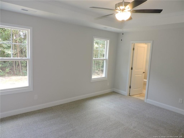 spare room featuring plenty of natural light, ceiling fan, and light colored carpet