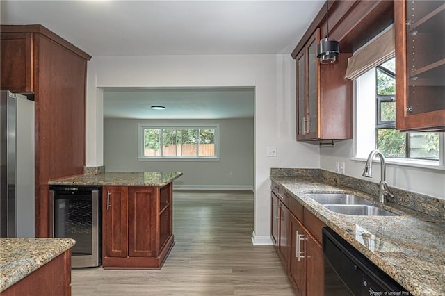 kitchen featuring stone countertops, freestanding refrigerator, a sink, beverage cooler, and dishwasher