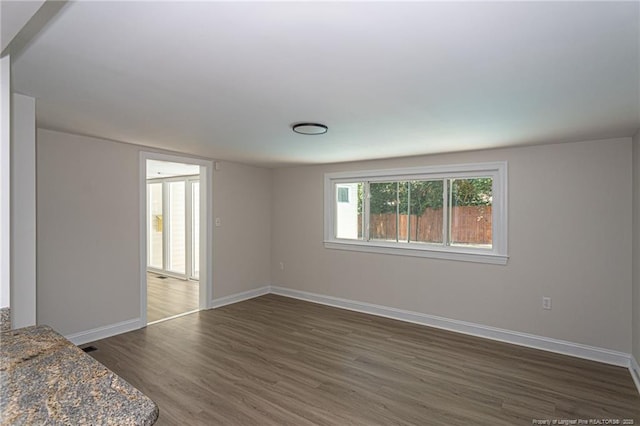 unfurnished bedroom featuring wood finished floors and baseboards