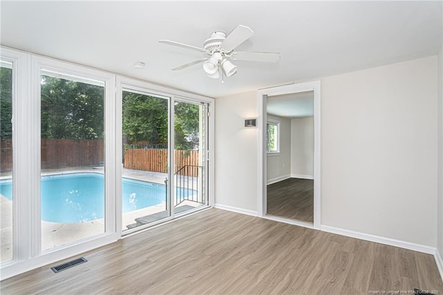 interior space with visible vents, baseboards, ceiling fan, and wood finished floors