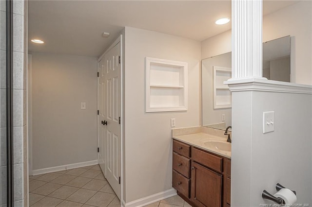 bathroom with decorative columns, vanity, baseboards, and tile patterned floors