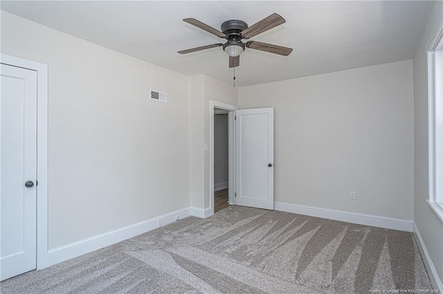 unfurnished bedroom featuring a ceiling fan, baseboards, visible vents, and carpet flooring