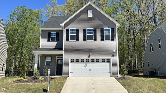 front of property featuring central AC, a front yard, and a garage