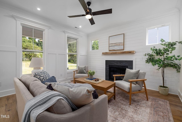 living room with crown molding, dark hardwood / wood-style floors, and ceiling fan