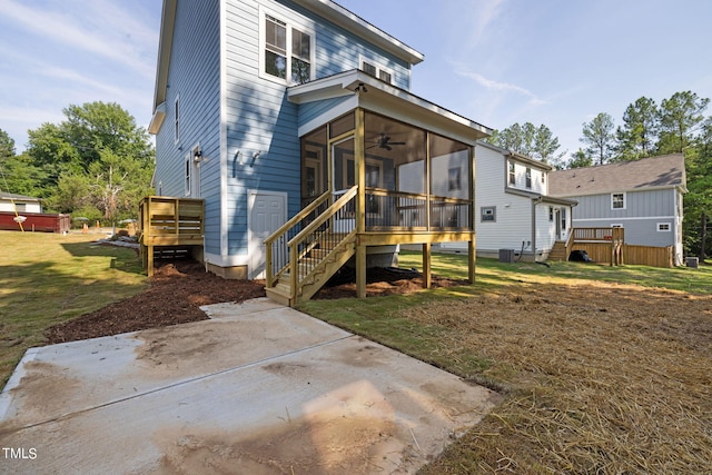 back of house featuring ceiling fan, a yard, and a sunroom