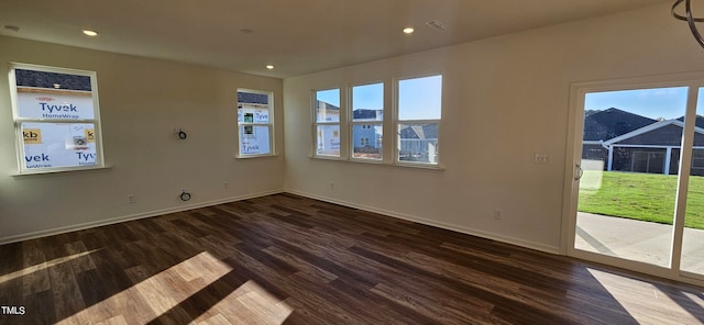 spare room featuring plenty of natural light and dark hardwood / wood-style floors