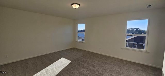 carpeted spare room featuring a water view