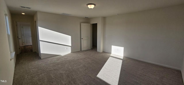 spare room with dark carpet