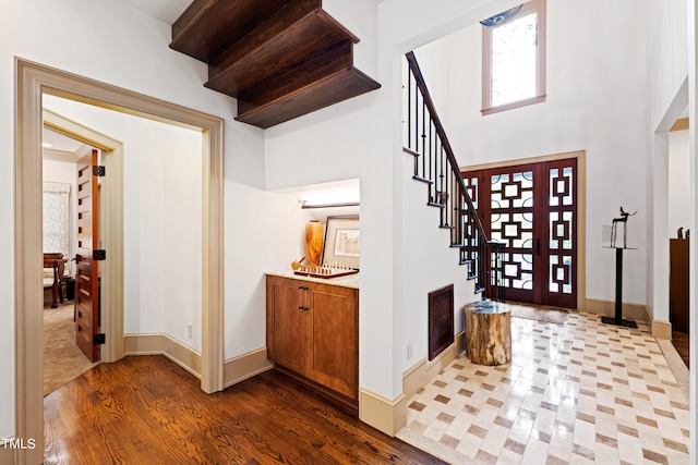 1800 Bay Meadow Ct, Raleigh, NC 27615 - foyer featuring stairs, baseboards, wood finished floors, a towering ceiling, and visible vents