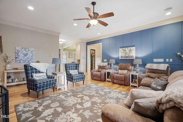 living room featuring crown molding, ceiling fan, and light wood-type flooring