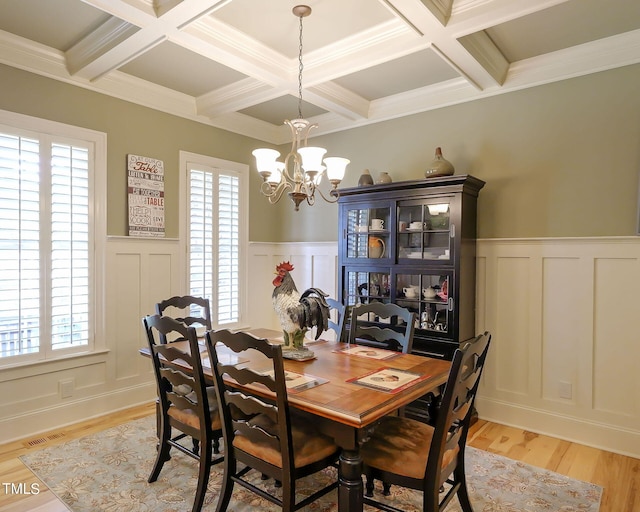 dining room featuring a notable chandelier, a wealth of natural light, ornamental molding, and light hardwood / wood-style floors