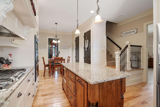 kitchen with light stone countertops, stainless steel appliances, white cabinets, and a kitchen island