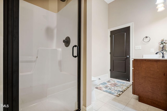 bathroom with tile patterned flooring, vanity, a shower with door, and toilet