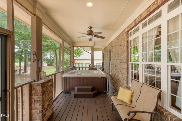 unfurnished sunroom with ceiling fan and a hot tub