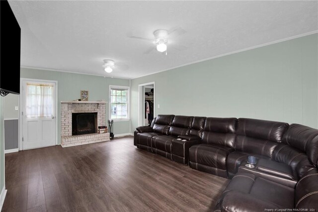 living room featuring a fireplace, dark wood-type flooring, ceiling fan, and ornamental molding