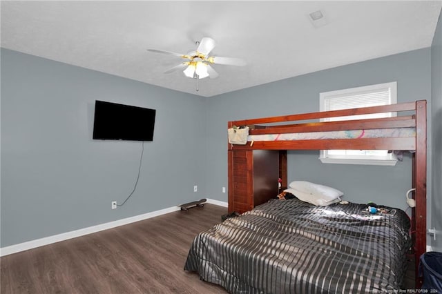 bedroom with dark hardwood / wood-style flooring and ceiling fan