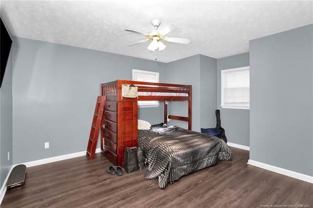 bedroom featuring ceiling fan, a textured ceiling, and dark hardwood / wood-style flooring