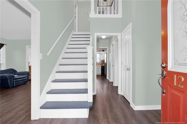 entrance foyer featuring dark hardwood / wood-style floors and a towering ceiling