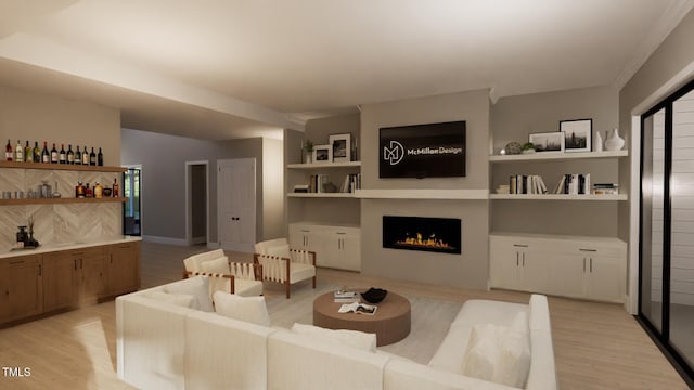 living room with a lit fireplace, built in shelves, light wood-type flooring, and baseboards