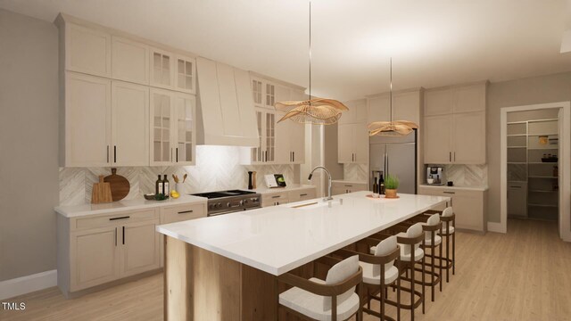 kitchen with appliances with stainless steel finishes, a sink, backsplash, and a kitchen bar