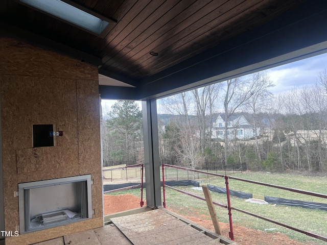 unfurnished sunroom featuring vaulted ceiling with skylight and wooden ceiling