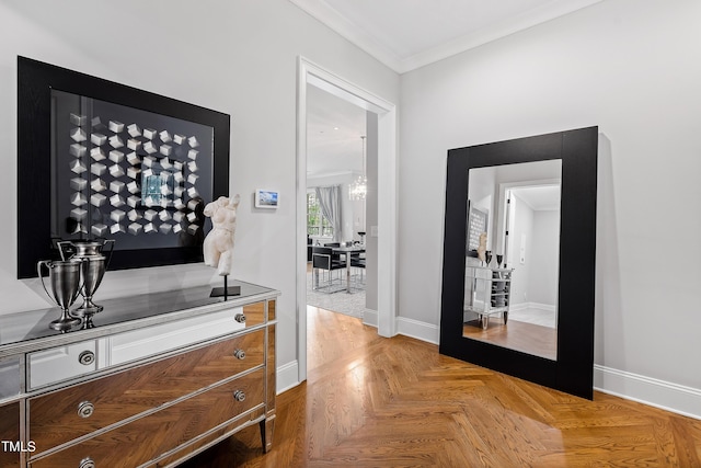 hallway featuring baseboards, ornamental molding, and an inviting chandelier