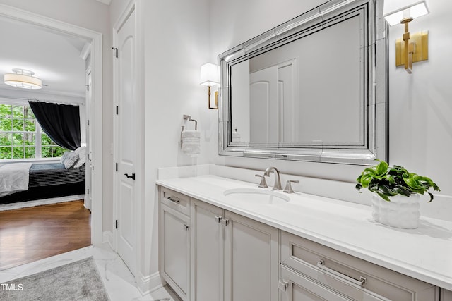 ensuite bathroom with marble finish floor, vanity, and ensuite bathroom