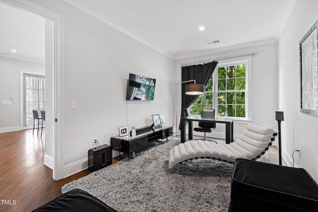 living area with ornamental molding and hardwood / wood-style flooring