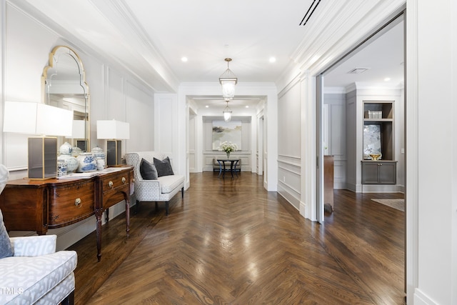sitting room with a decorative wall, crown molding, visible vents, and recessed lighting
