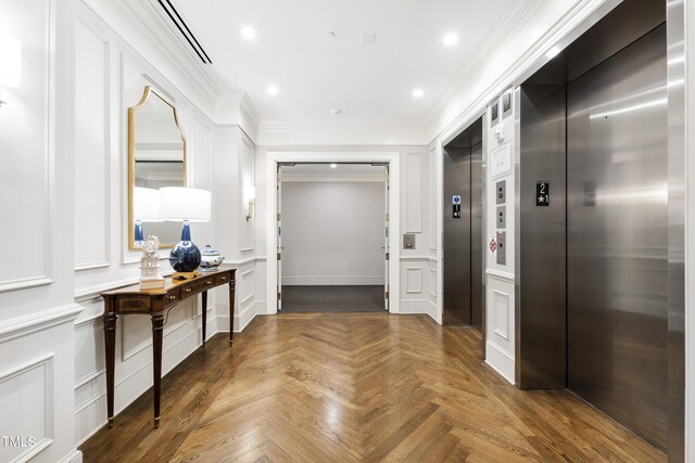 corridor with ornamental molding, parquet flooring, and elevator