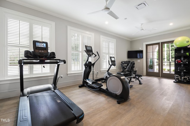 exercise area with wood finished floors, visible vents, a ceiling fan, and ornamental molding