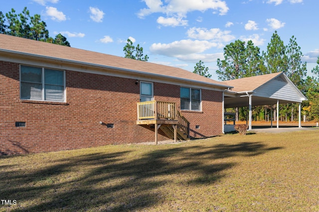 rear view of property with a lawn and a carport