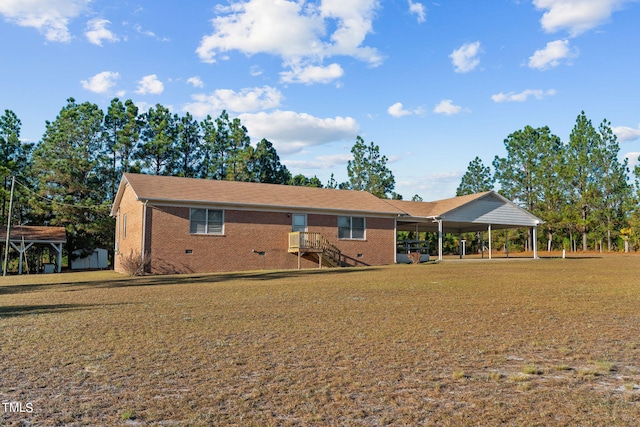 back of house with a carport and a yard