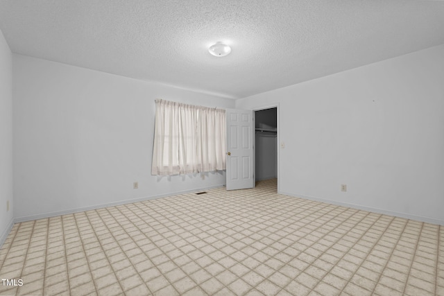 unfurnished bedroom featuring a textured ceiling and a closet