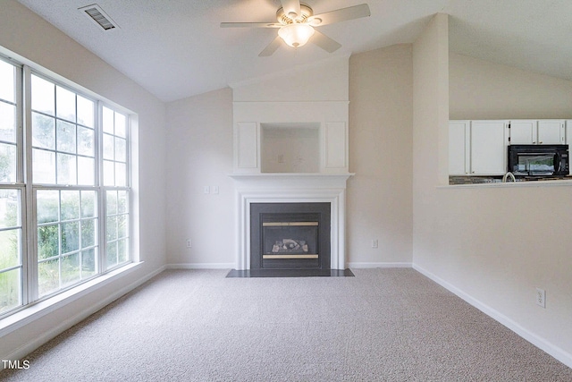 unfurnished living room featuring ceiling fan, light colored carpet, and lofted ceiling