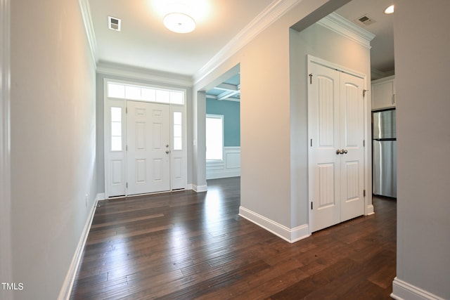 foyer entrance with ornamental molding and dark hardwood / wood-style flooring