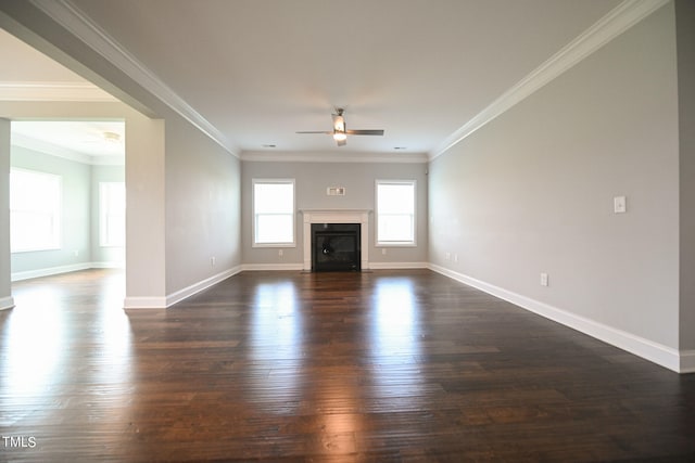 unfurnished living room with ceiling fan, dark wood-type flooring, and crown molding