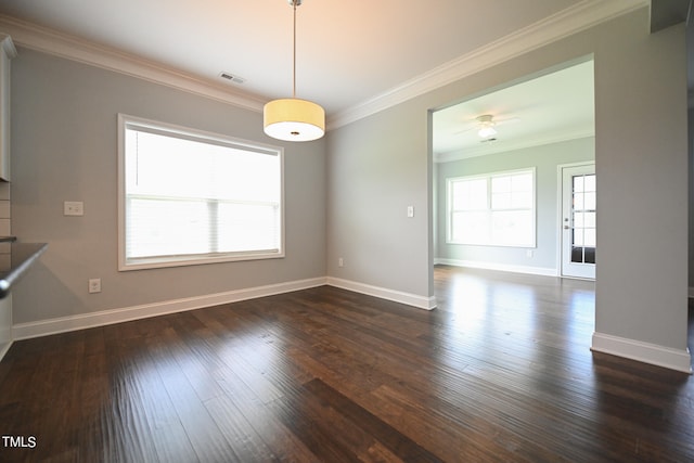 unfurnished dining area with ceiling fan, a healthy amount of sunlight, crown molding, and dark wood-type flooring