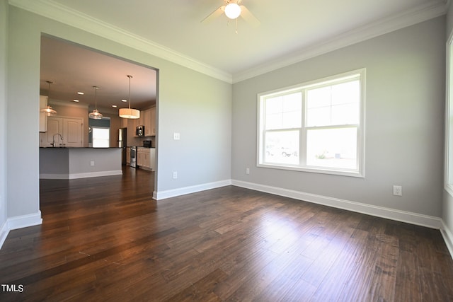 unfurnished living room with sink, crown molding, dark hardwood / wood-style floors, and ceiling fan