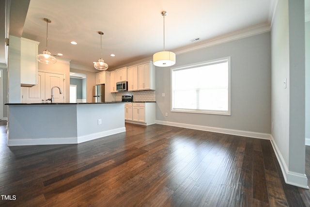 kitchen with appliances with stainless steel finishes, dark hardwood / wood-style flooring, and white cabinets