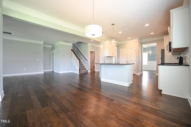 kitchen with white cabinets, backsplash, a center island, dark hardwood / wood-style flooring, and hanging light fixtures