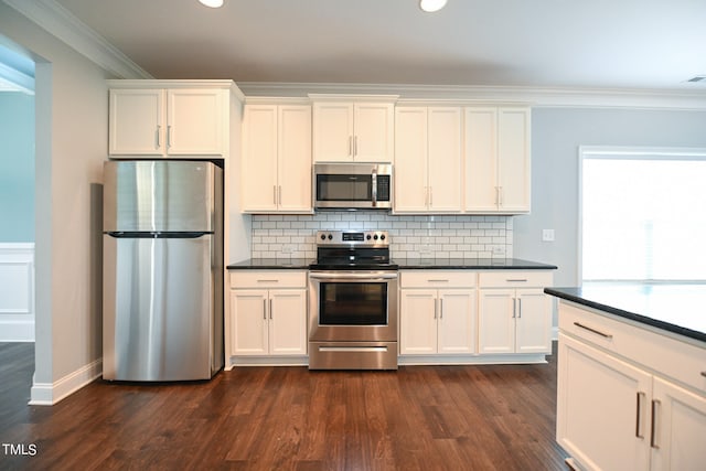 kitchen featuring white cabinetry, backsplash, dark hardwood / wood-style floors, appliances with stainless steel finishes, and ornamental molding