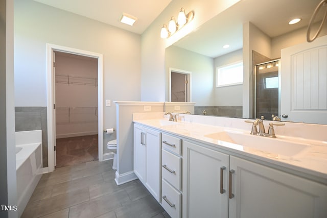 bathroom with tile patterned flooring, a washtub, toilet, and double sink vanity